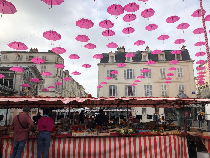 法國拉洛歇爾小鎮的市集在十月的天空有許多粉色的雨傘